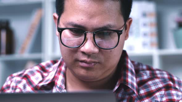 Portrait close up Asian glasses man looking to screen monitor with stressed face at home