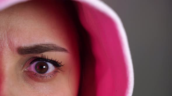 Portrait of Young Woman in Hood Frowning and Looking at Camera