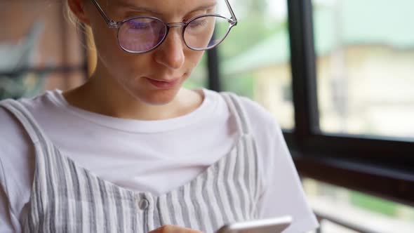 Woman using smartphone near window