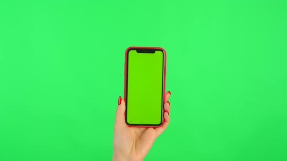 Woman Holds Mobile Phone with Workspace Mock Up Screen in Her Hands on Green Background in Vertical