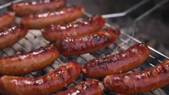 Closeup View of Tasty Sausages Grilling on Charcoal Grill Grate