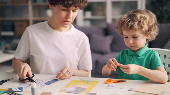 Small Boy Helping His Mother Designer Creating Colorful Paper Collage at Home