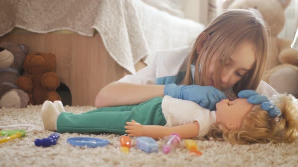 Beautiful Little Girl Playing Doctors with Doll at Home