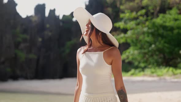 Smiling Woman In Sun Hat Walking Along Hidden Beach