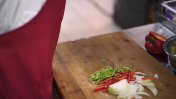 Close Up View of Cook Hand Chopping Peppers with a Knife on Cutting Board