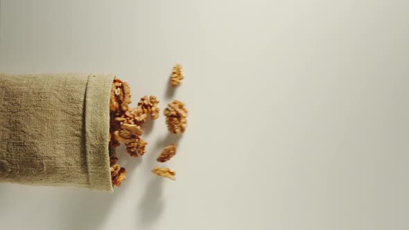 Bag Falls And Peeled Walnuts Are Poured Out Of It On White Background