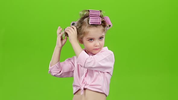 Little Girl with Curlers on His Head, Removes Curlers. Green Screen. Slow Motion