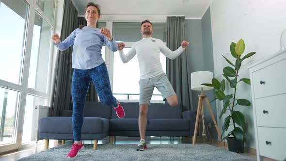 Caucasian Couple is Doing Cardio Exercise at Home in Cozy Bright Room Slow Motion