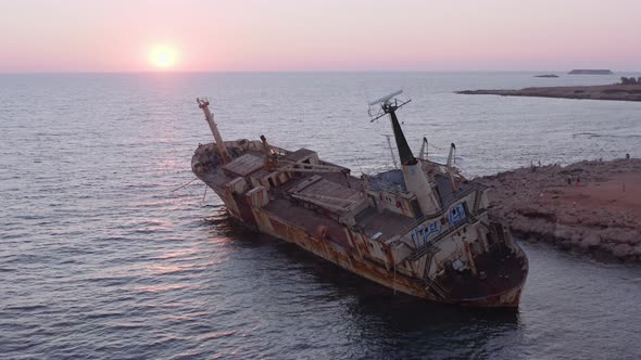Aerial Of Rusty Shipwreck Close To Shore With Crashing Waves During Sunset 11
