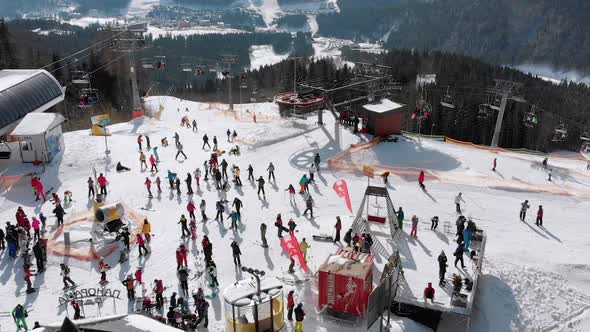 Aerial View Crowd of Skiers Skiing on Peak Ski Slope Near Ski Lifts. Ski Resort