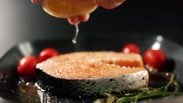 A Chef's Hand is Squeezing a Fresh Lime Over a Peace of Red Sea Fish