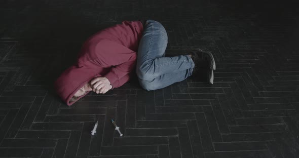 Addicted Young Man Lying on the Floor