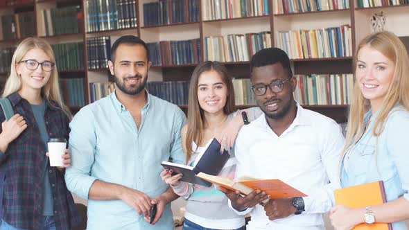 Portrait of Multiethnic Diverse Friends Pupils Looking at Page of Interesting Book in College