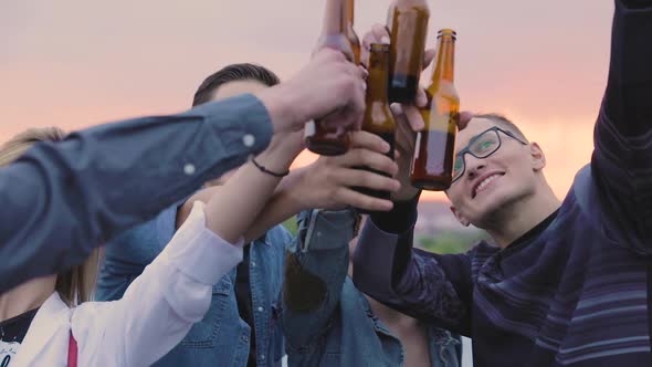 Happy Friends Drinking Beer, Cheering With Bottles And Dancing