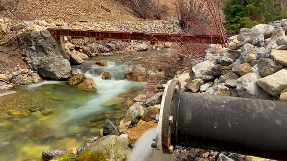 Long exposure time lapse of a river flowing down a mountainside - white water is smooth wispy and su