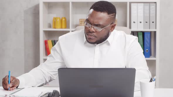 Workplace of freelance worker at home office. Young African-American man.