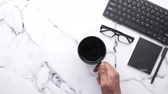 High Angle View of Man Hand Drinking Coffee on Office Desk 