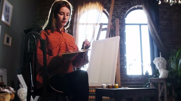 A Young Woman in Art Workshop Mixing Shades on a Palette