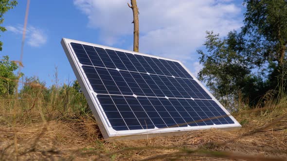 Portable Solar Panel Against Sky and Clouds Lying on the Ground Used in Tourism