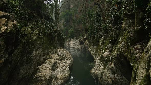 Flying Over a River Through a Narrow Canyon with White Rocks Sochi