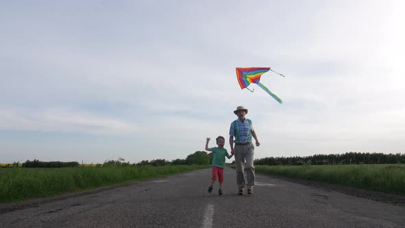 Joyful Grandpa with Grandson Flying Kite Outdoor