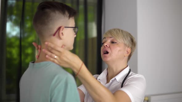 The Adult Woman Doctor is Checking the Lymph Nodes of Young Boy