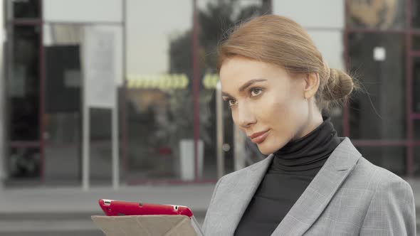 Beautiful Businesswoman Using Digital Tablet Outdoors in the City