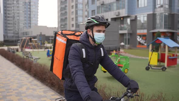 Delivery Courier Riding Bike Past Urban Playground