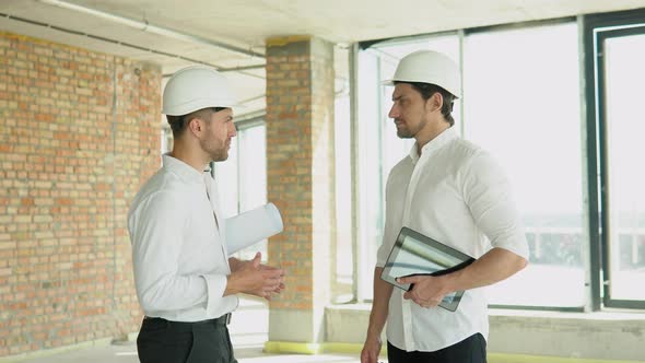 Friendly Handshake of Two Builders at a Construction Site