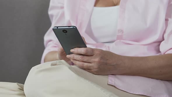 Retired Female Holding Smartphone Scrolling Its Screen, Easy Mobile Applications