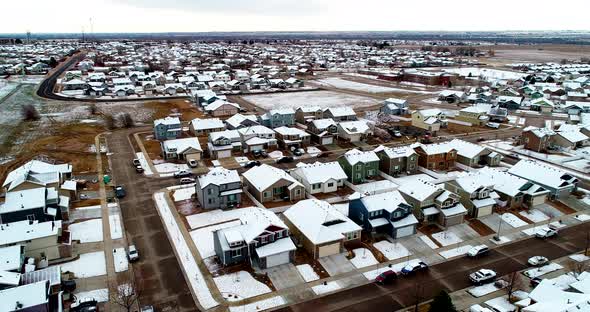 Cold snow covers the rooftops in this suburban neighborhood in late March before the spring season b