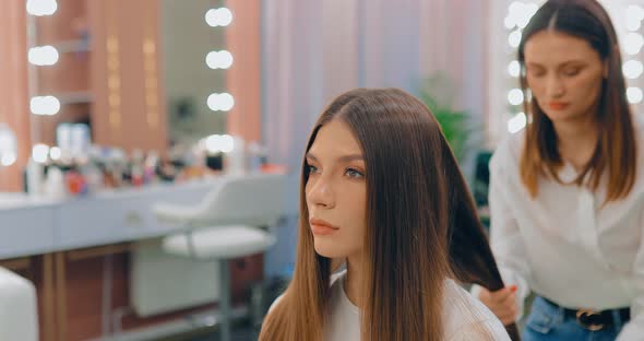 Stylist Applies Cosmetics to the Girl’s Hair