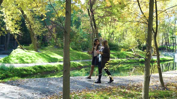 Businesswomen Walking in Park During Coffee Break