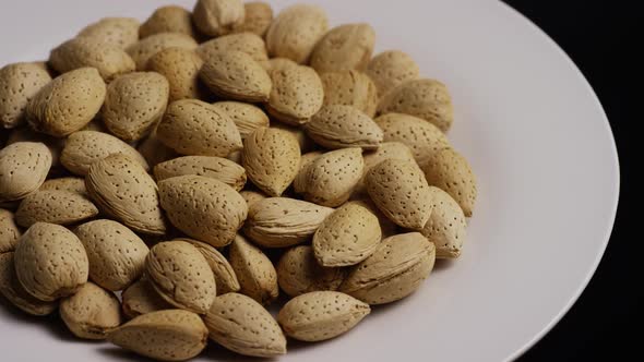 Cinematic, rotating shot of almonds on a white surface 