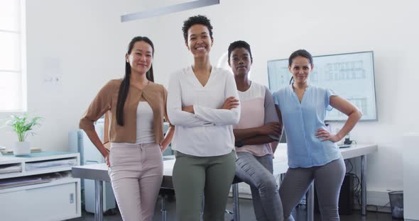 Group of happy diverse businesswomen standing in office and looking at camera