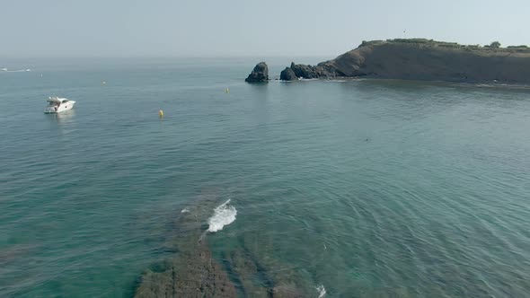 Man Is Standing on a Rock Cliff Above a Blue Sea