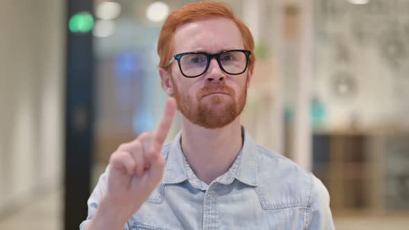 Serious Young Redhead Man Saying No By Finger Sign