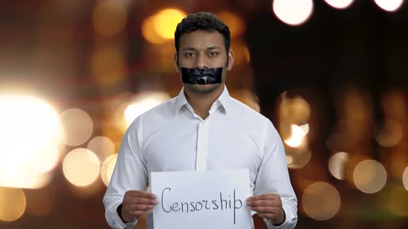 Businessman with Taped Mouth Holding Card with Word Censorship