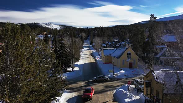 Aerial forward view of mountain road with passing cars and snow around.  Denver, Colorado. Real time