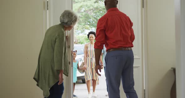 African american grandparents embracing and greeting their smiling family