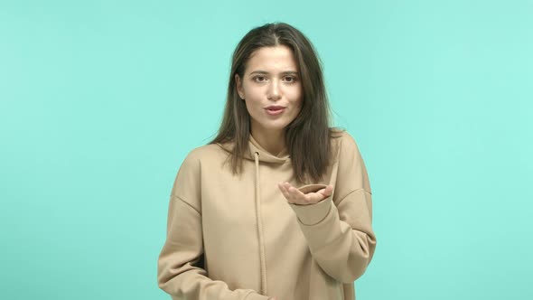 Beautiful Female Model with Dark Hair Beige Hoodie Pointing at Camera Then Start to Refuse Offer