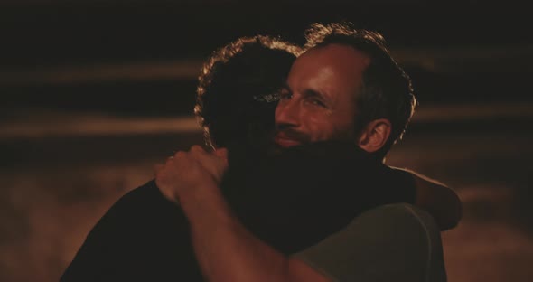 Two men hugging and embracing friendship in a wine cellar