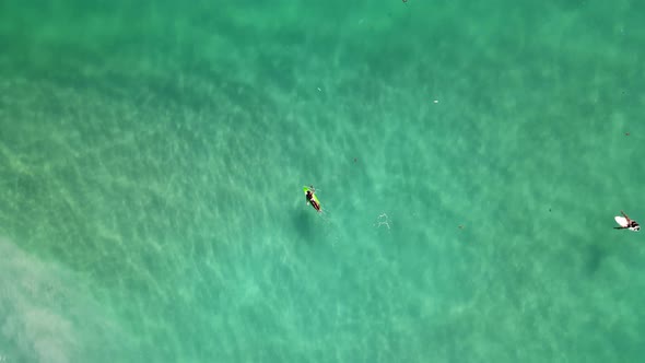 Aerial Birds Eye View Over Surfers Floating To Catch Waves Off Kata Beach In Phuket. Pedestal Up