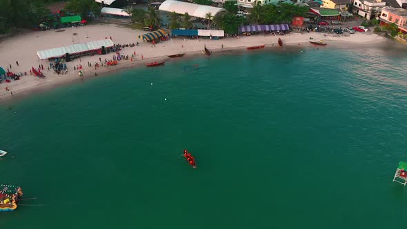 Aerial boat teams in rowing competitions in bay of tropical island.