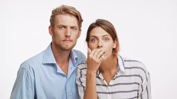 Young Caucasian Pair Looking at Camera in Slowmotion with Suspicion and Disapproval on White