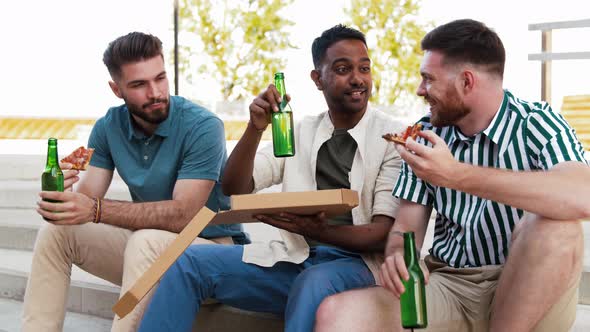 Male Friends Eating Pizza with Beer on Rooftop