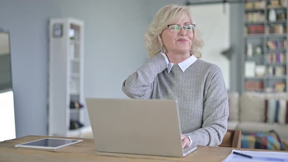 Beautiful Old Woman Having Neck Pain in Modern Office