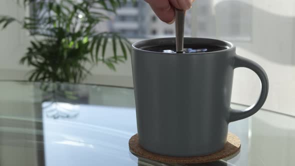 A Large Cup of Coffee on the Table Stir the Drink with a Spoon