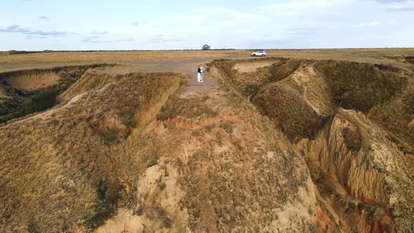 Above View of Young Couple Standing Close Hugging Up on High Hill of Seashore