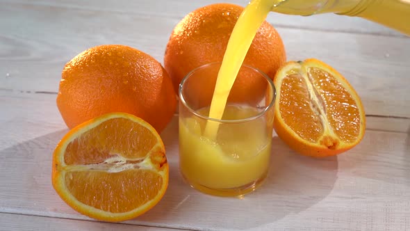 Super Slow Motion Shot of Pouring Fresh Orange Juice Into Glass